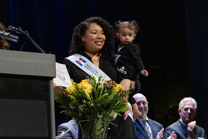 SEHD alum Janet Damon accepting the 2025 Colorado Teacher of the Year award with granddaughter Mila Lavender